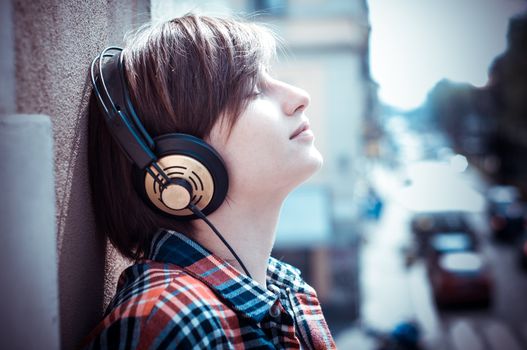 young hipster woman listening to music on balcony
