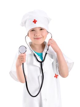 Portrait of a smiling little girl wearing as a nurse on white uniform and holding a stethoscope in hand. Isolated on white background.