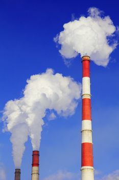 Smoking pipes of thermal power plant against blue sky