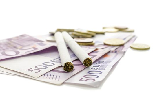 Cigarettes on European currency. Over white background. Concept of how expensive smoking is. 