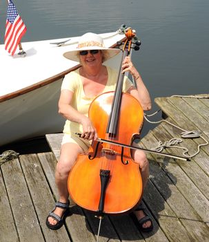 Female cellist performing on the lake.