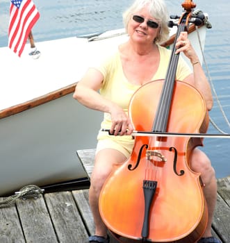 Female cellist performing on the lake.