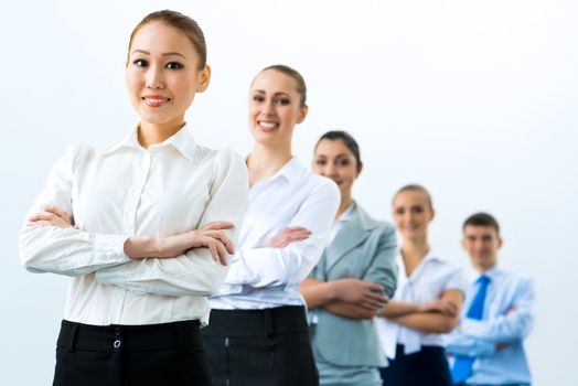 group of business people standing in a row, smiling and crossing his arms