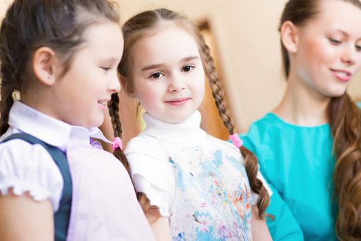 girl in the school, near the teacher and other children