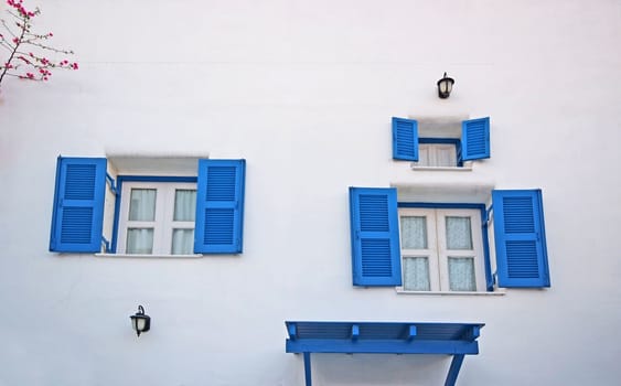 Vintage blue windows on the white wall.