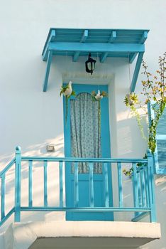 Vintage blue door and window and terrace Decorative with basket flowers on the white wall.