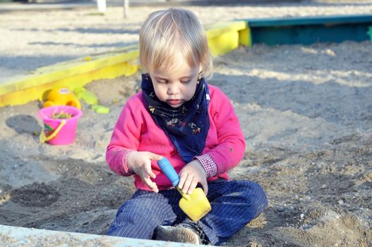 two years old blonde blue eyes beautiful kid at the playground