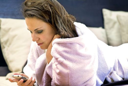 beautiful lady in dressing gown with telephone on a bed