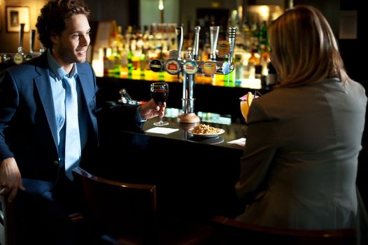 Attractive couple refreshing themselves at the bar. Enjoying drinks