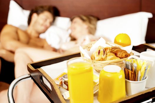 Let's wake up with healthy breakfast sweetheart. Couple romancing in bed