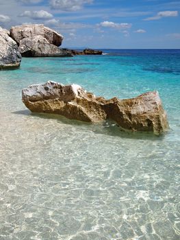 Big rocks in the shallow emerald sea on a beach on the Costa Smeralda in Sardinia, Italy.
