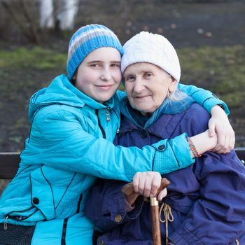 Granddaughter embracing her grandmother on the street