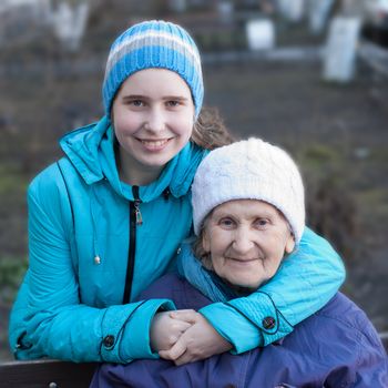 Granddaughter embracing her grandmother on the street