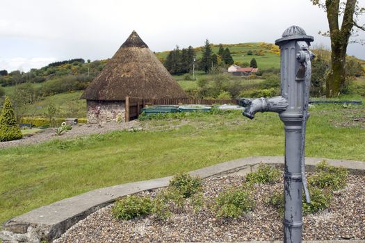 water pump and celtic thatched hut in the Irish countryside