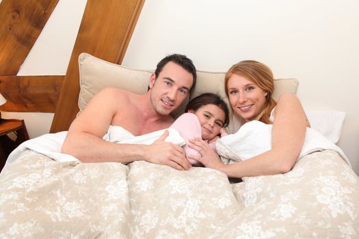 Parents with daughter in bed