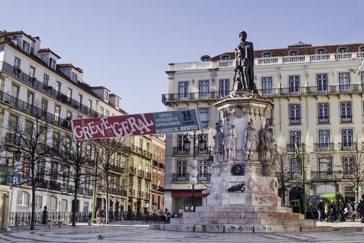 Camoes square at Bairro Alto - Chiado district in Lisbon, with a monument to the great portuguese epic poet Luis de Camoes (Victor Bastos, 1867), and a poster organizing a general strike related to European crisis