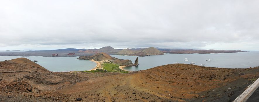 Panorama from the Bartolome Island overlook, showing Pinnacle Rock, cruise ships, Sullivan Bay and Santiago Island, Galapagos National Park, Ecuador