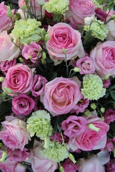 Pink roses and green white carnations in a bridal flower arrangement