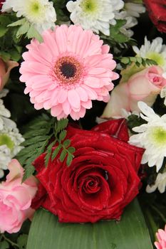 Red roses and pink gerberas in a mixed wedding centerpiece