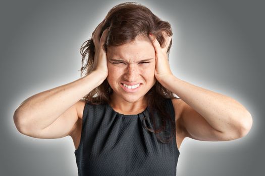 Woman suffering from an headache, holding her hands to the head