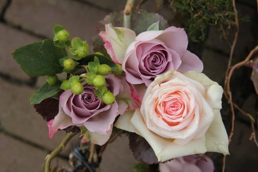 Big pink and purple roses in a wedding centerpiece
