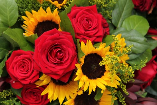 Big red roses and sunflowers in a floral arrangement