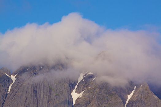 Scenic mountain peaks covered by clouds on Lofoten islands in Norway