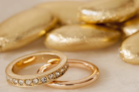 wedding favors and wedding ring on on colored background