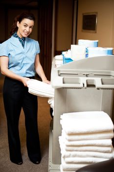 Housekeeping in charge pulling out the bath towel from the cart to deliver it to rooms