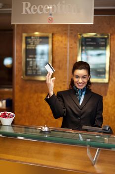 Beautiful receptionist posing with customers cash card. Casual portrait