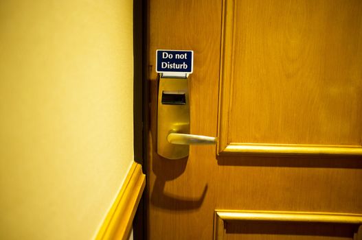 Cropped image of hotel room with do not disturb tag on door knob
