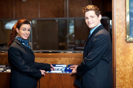 Casual shot of young help desk executives checking customer records while posing in front of camera