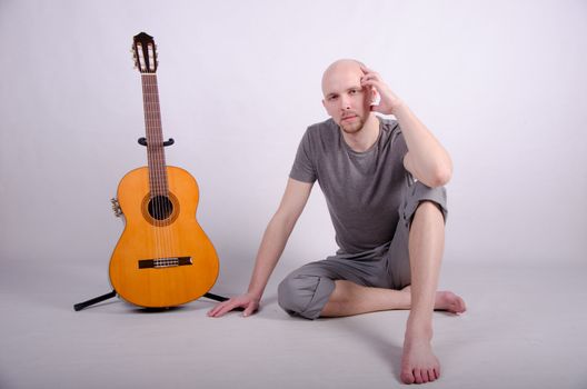 Nice bald guy with a guitar in the studio