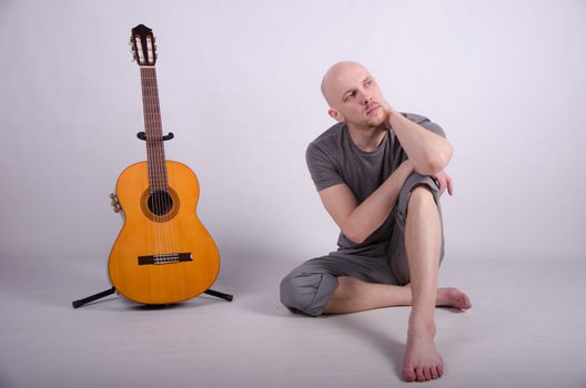 Nice bald guy with a guitar in the studio