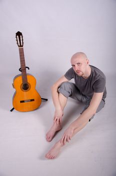 Nice bald guy with a guitar in the studio