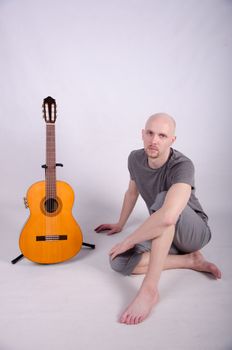 Nice bald guy with a guitar in the studio