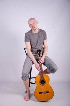 Nice bald guy with a guitar in the studio