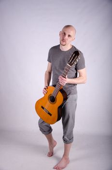 Nice bald guy with a guitar in the studio