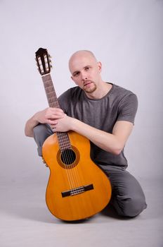 Nice bald guy with a guitar in the studio