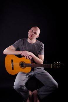 Nice bald guy with a guitar in the studio