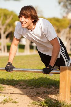 young healthy man making exercise in a public park