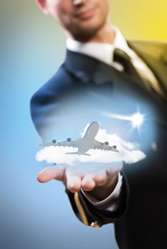 pilot in the form of extending a hand to a flying airplane with sky, clouds and sun