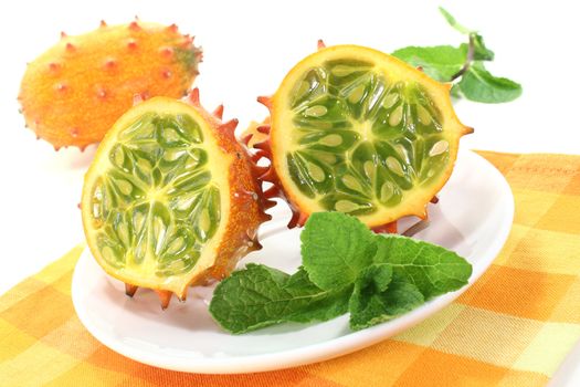 fresh horned melon on a plate with napkin on a light background