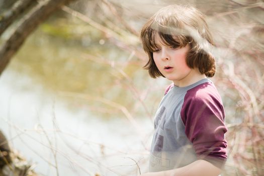 Thoughtful boy by a river