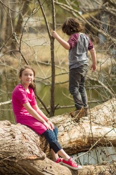 Brother and sister on a tree over a river