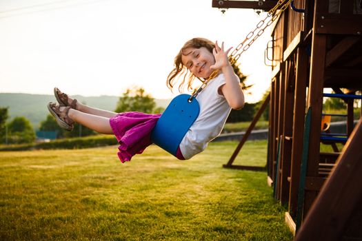 Little girl on a swing in a playground