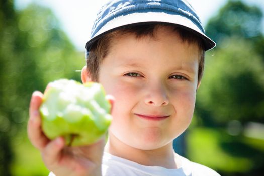 Boy eating a green apple