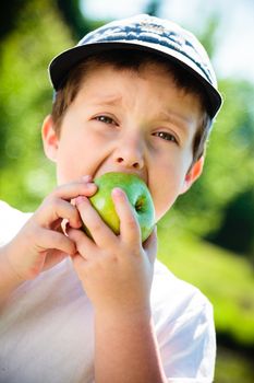 Boy eating a green apple