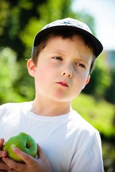 Boy eating a green apple