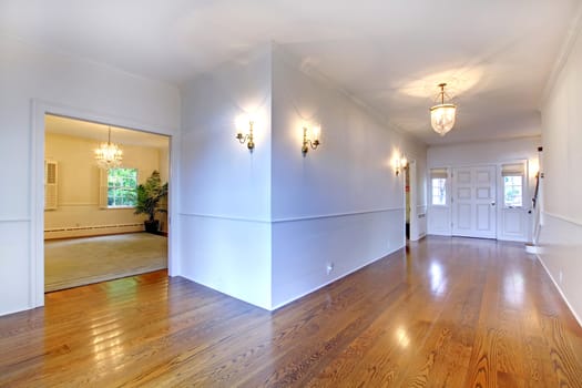 Large bright hallway with hardwood floor and dining room.